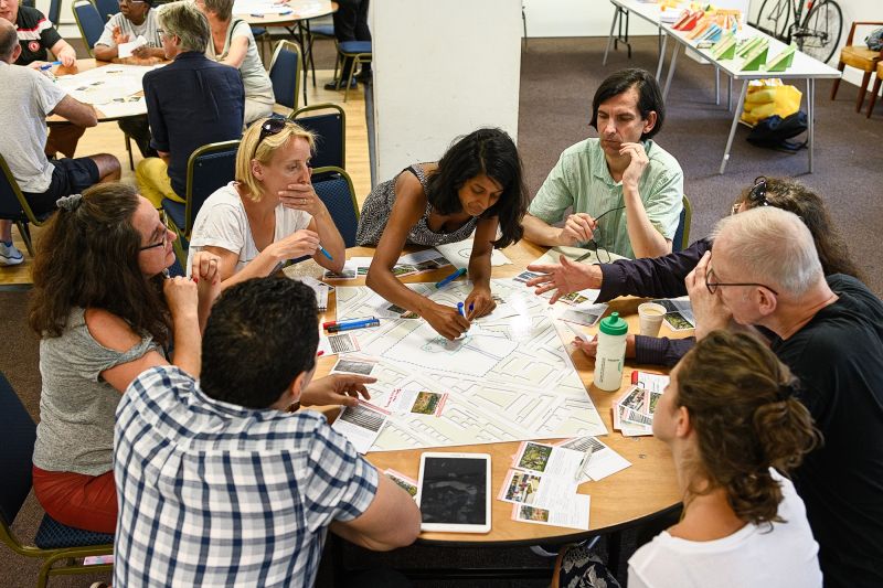 Menschen verschiedener Generationen beraten gemeinsam an einem Tisch über Pläne