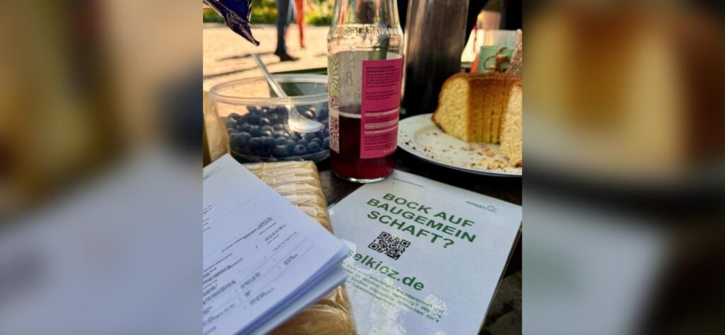 Flyer „Bock auf Baugemeinschaft?“ auf einem Tisch beim Kennenlerntreffen
